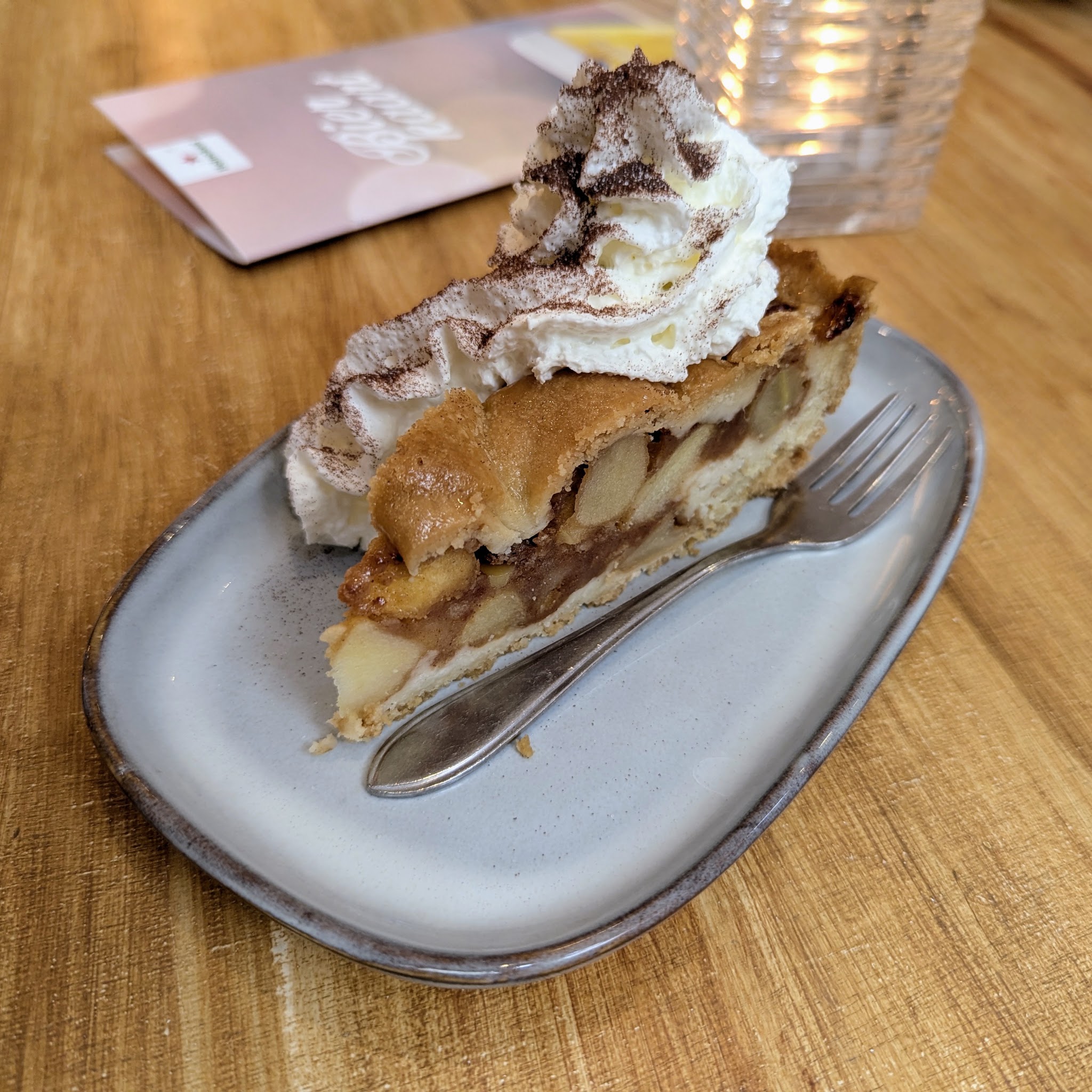 Een punt appeltaart met slagroom op een bord